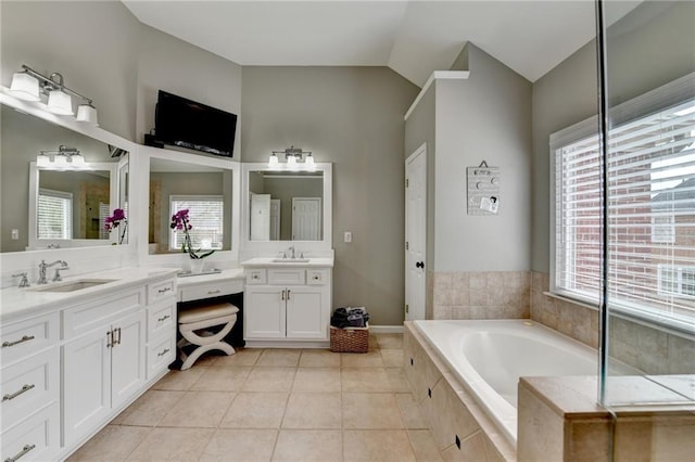 full bath featuring vanity, vaulted ceiling, a bath, and tile patterned floors