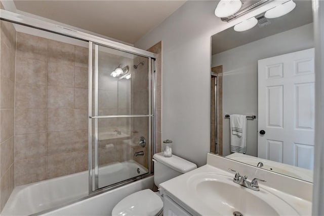 bathroom with toilet, visible vents, combined bath / shower with glass door, and vanity