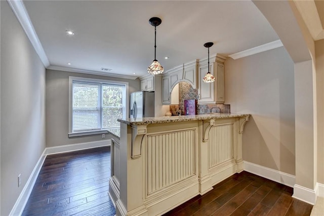 kitchen with a peninsula, dark wood-style floors, cream cabinets, and stainless steel refrigerator with ice dispenser