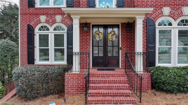 entrance to property featuring french doors and brick siding