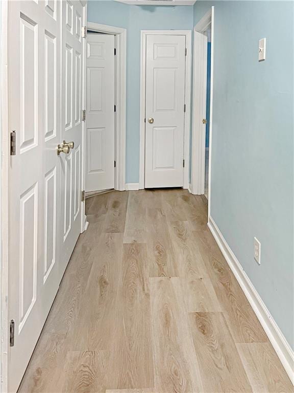 corridor with light hardwood / wood-style floors