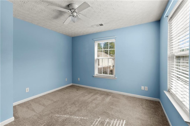 empty room with ceiling fan, carpet floors, and a textured ceiling