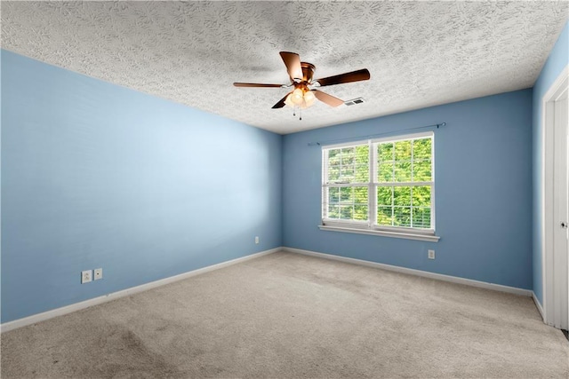 carpeted empty room featuring a textured ceiling and ceiling fan