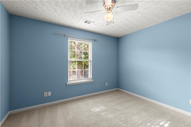 carpeted spare room with a textured ceiling and ceiling fan