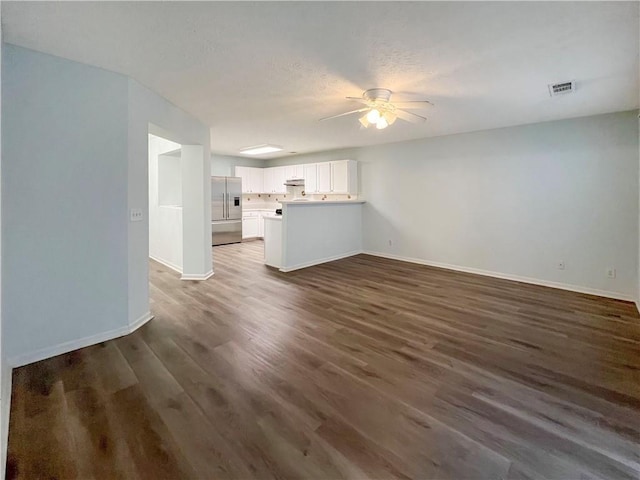 unfurnished living room with dark hardwood / wood-style floors and ceiling fan