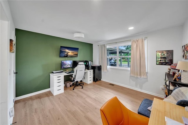 office space with visible vents, baseboards, and wood finished floors