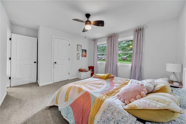 carpeted bedroom featuring ceiling fan and baseboards