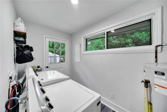 clothes washing area featuring baseboards, washing machine and dryer, laundry area, and water heater