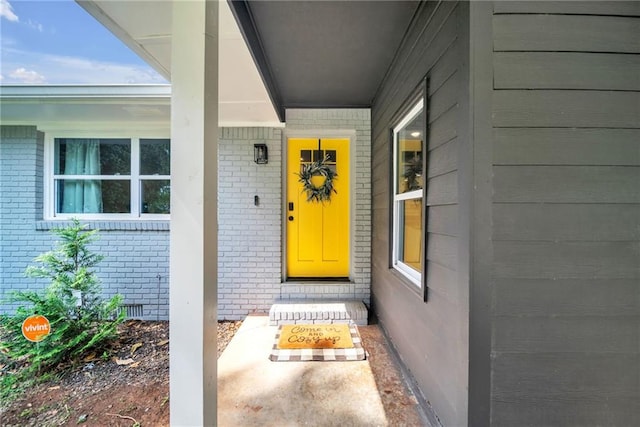 property entrance with crawl space and brick siding