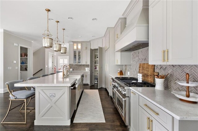 2110 Timball Rd NW, Atlanta, GA 30318 - kitchen featuring appliances with stainless steel finishes, custom range hood, tasteful backsplash, a kitchen island with sink, and a breakfast bar area