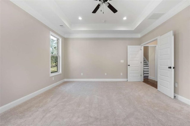unfurnished bedroom featuring ornamental molding, baseboards, light colored carpet, recessed lighting, and a raised ceiling