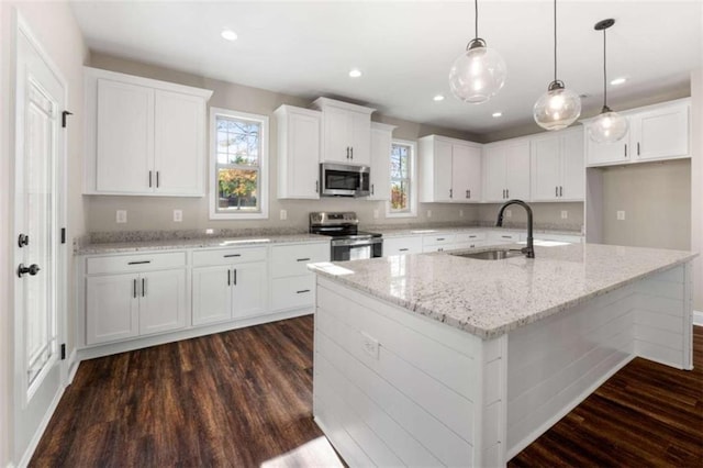kitchen featuring a sink, appliances with stainless steel finishes, white cabinets, and dark wood-style floors