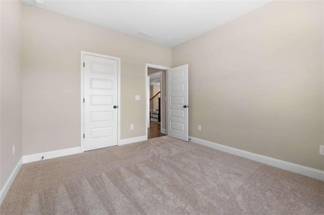 empty room with baseboards and carpet
