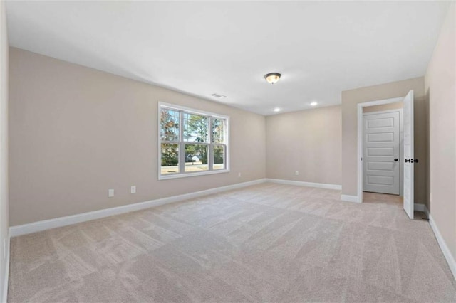 unfurnished room with baseboards, light carpet, and recessed lighting