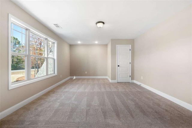 empty room featuring visible vents, recessed lighting, baseboards, and light carpet