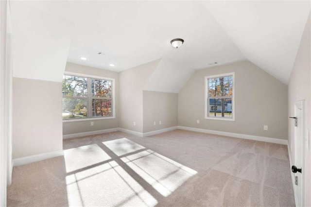 additional living space featuring a healthy amount of sunlight, carpet floors, and vaulted ceiling