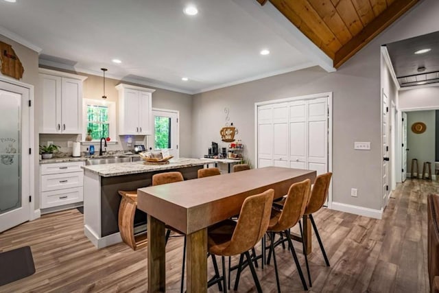 kitchen with white cabinets, a center island, wood finished floors, and recessed lighting