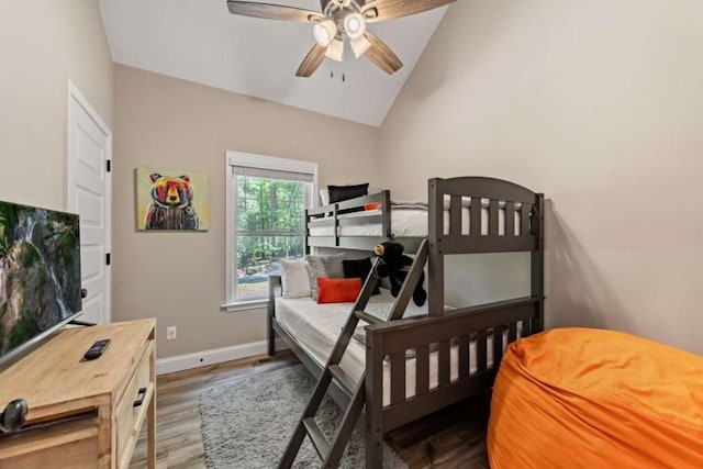 bedroom featuring vaulted ceiling, baseboards, a ceiling fan, and wood finished floors