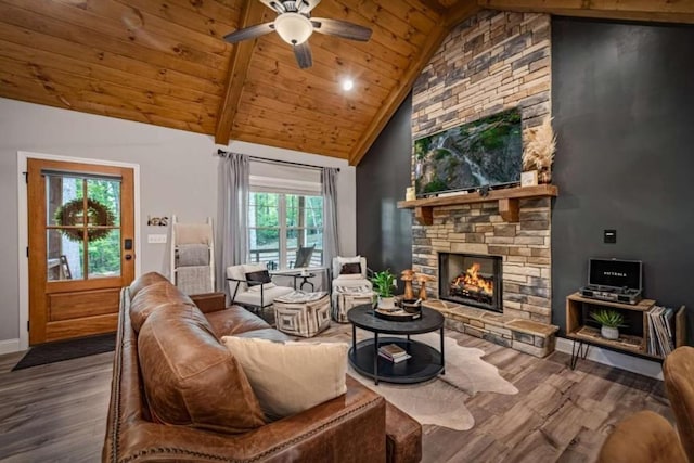 living area featuring wood finished floors, ceiling fan, wood ceiling, baseboards, and a stone fireplace
