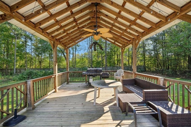 wooden terrace featuring a grill, ceiling fan, fence, and an outdoor hangout area