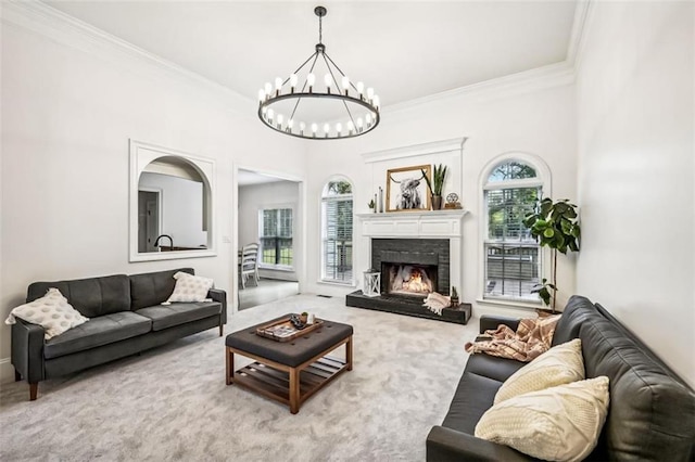 living room with a warm lit fireplace, carpet flooring, crown molding, and an inviting chandelier