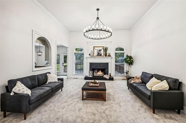 carpeted living area with ornamental molding, a warm lit fireplace, and a notable chandelier