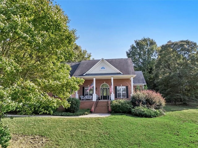 neoclassical home featuring covered porch, brick siding, and a front lawn