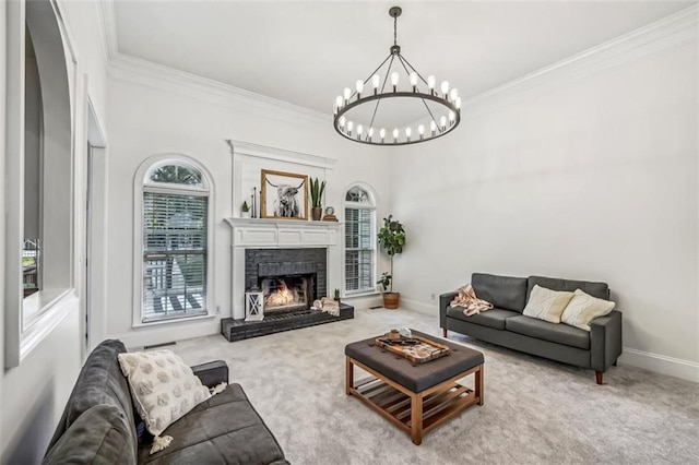 carpeted living room featuring ornamental molding, a warm lit fireplace, baseboards, and an inviting chandelier