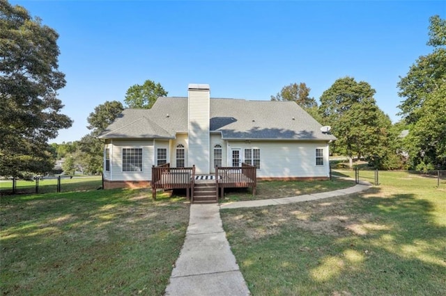 back of house with a yard, a chimney, a wooden deck, and fence