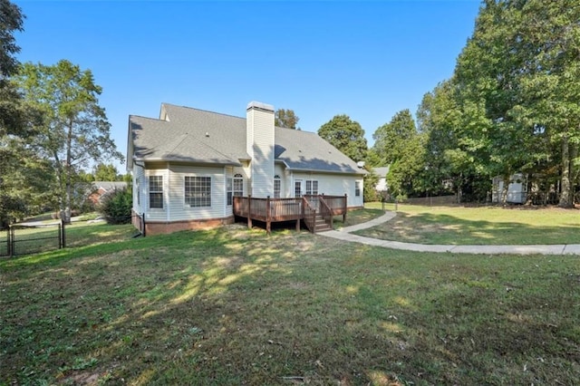 rear view of house featuring a deck, a yard, a chimney, and fence