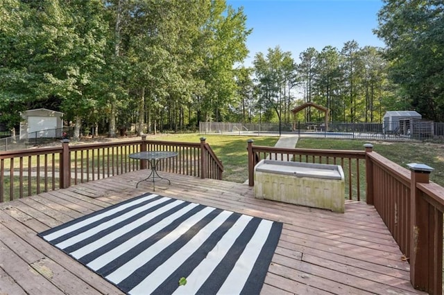 wooden terrace featuring fence, an outdoor structure, and a yard