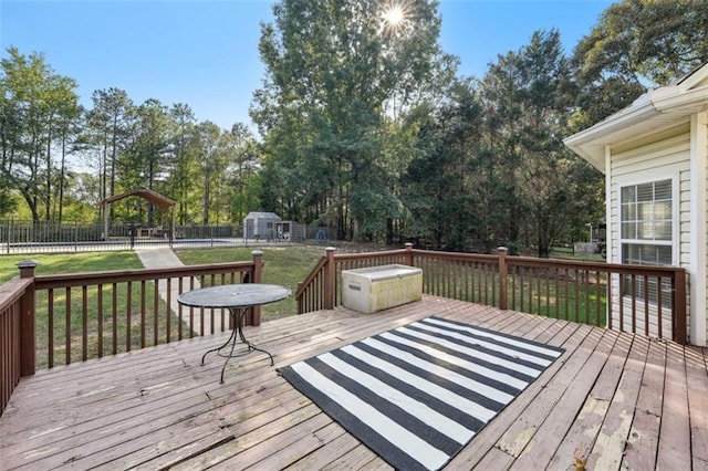 wooden terrace featuring a lawn and fence