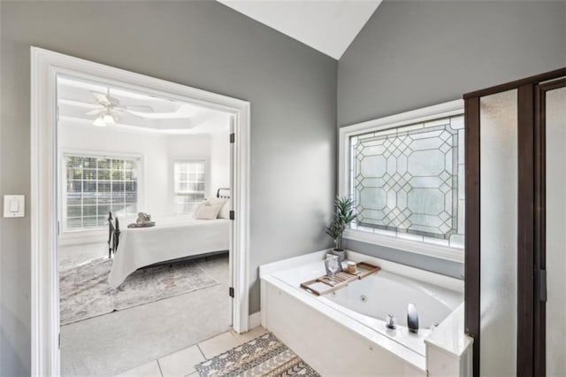 full bath with a raised ceiling, ceiling fan, ensuite bath, tile patterned flooring, and a jetted tub