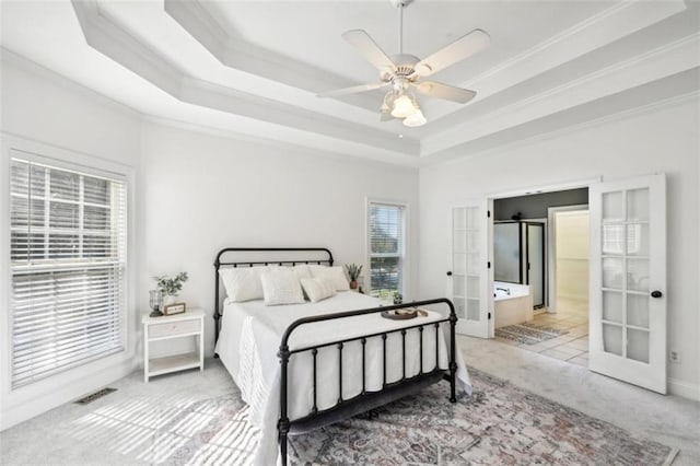 bedroom with a tray ceiling, french doors, crown molding, visible vents, and light carpet