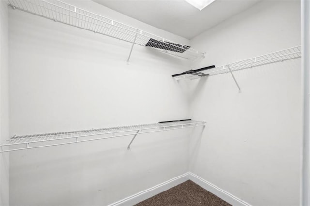 spacious closet with visible vents and dark carpet