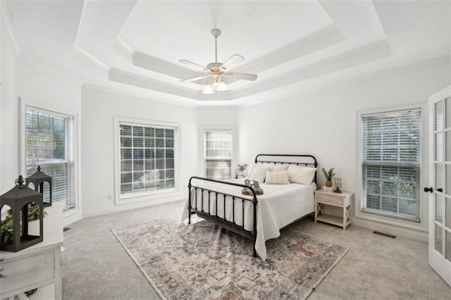 bedroom featuring visible vents, a ceiling fan, ornamental molding, french doors, and a tray ceiling