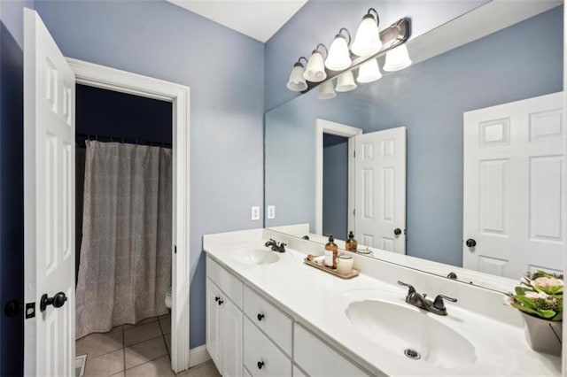 bathroom with double vanity, tile patterned flooring, a sink, and toilet