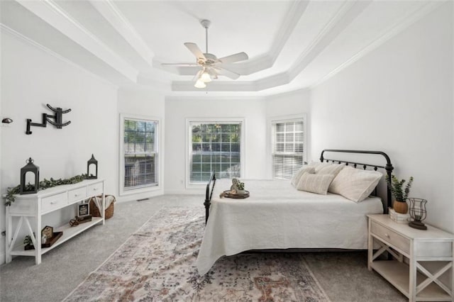 carpeted bedroom featuring ornamental molding, a raised ceiling, and a ceiling fan