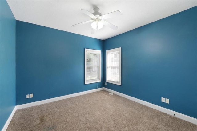 empty room featuring ceiling fan, carpet floors, and baseboards