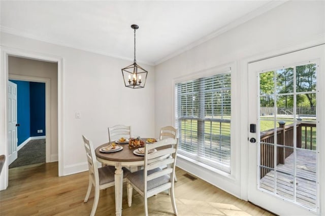 dining area featuring visible vents, light wood-style floors, baseboards, ornamental molding, and an inviting chandelier