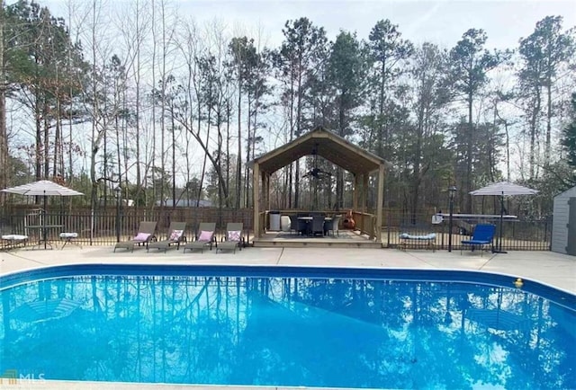 view of pool with fence, a deck, a fenced in pool, and a gazebo