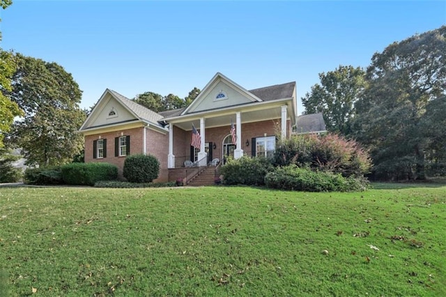 neoclassical home featuring covered porch, brick siding, and a front yard