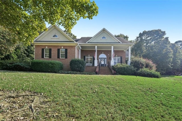 greek revival house featuring a front lawn and brick siding