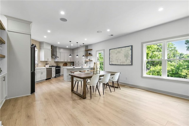 42 Riverdale St, Canton, GA 30114 - kitchen featuring appliances with stainless steel finishes, a sink, light countertops, pendant lighting, and wall chimney range hood