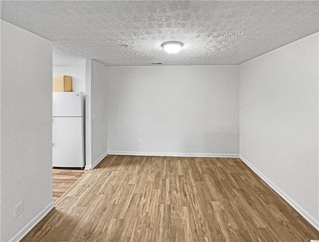 carpeted spare room with ceiling fan and a textured ceiling