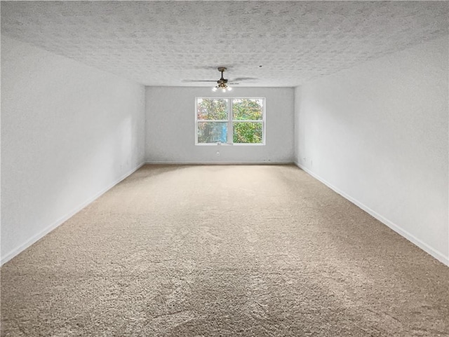 empty room with carpet flooring, ceiling fan, and a textured ceiling