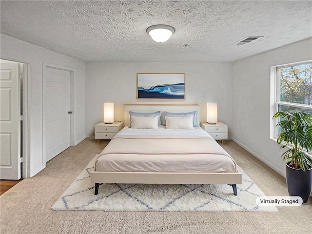 carpeted bedroom featuring a textured ceiling