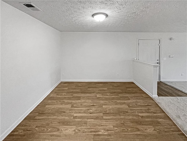 unfurnished room featuring a textured ceiling and hardwood / wood-style flooring