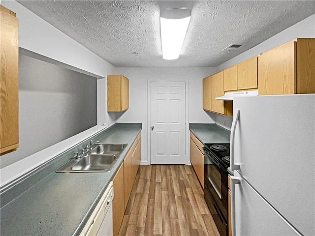 kitchen featuring a textured ceiling, light wood-type flooring, white appliances, and sink