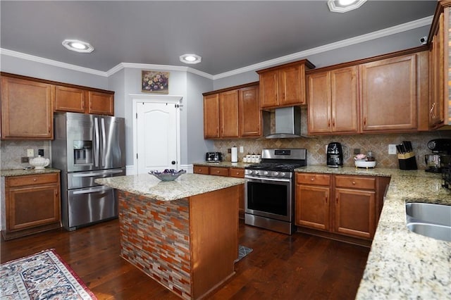 kitchen featuring brown cabinetry, wall chimney exhaust hood, and appliances with stainless steel finishes